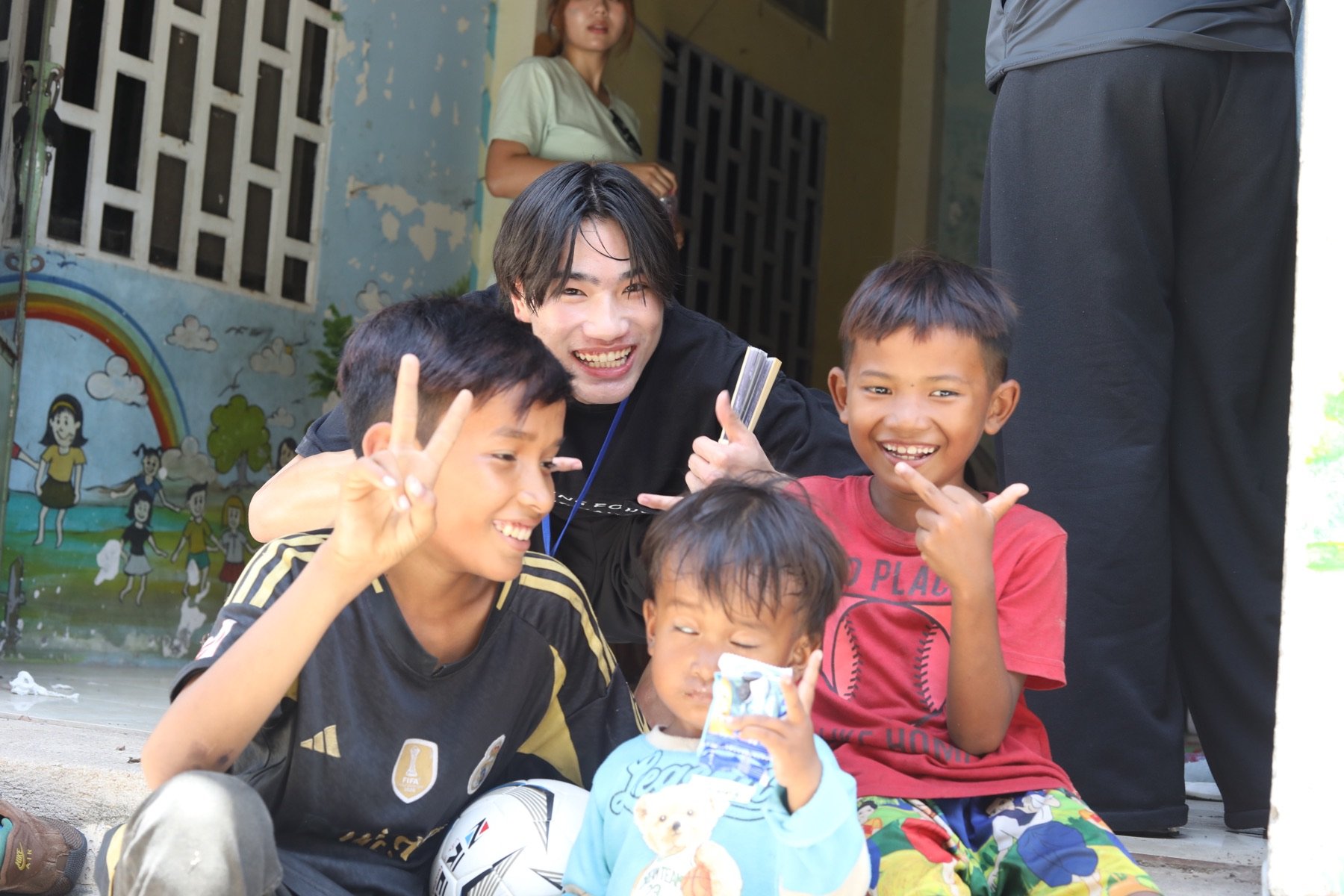 参加者と現地の子どもたちが一緒に写真に写る様子