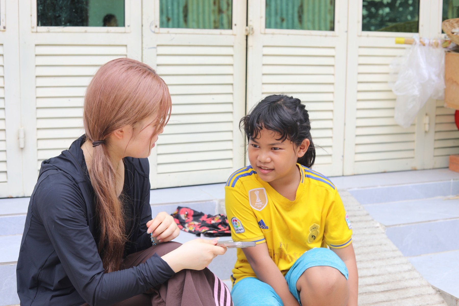 参加者が現地の子どもと向き合って話している場面