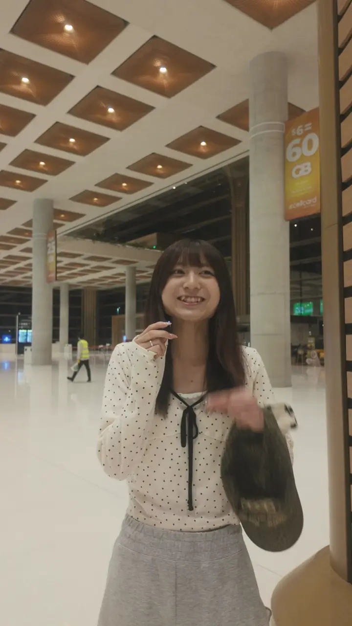 到着した夜の空港で、笑って話すりんかさん
